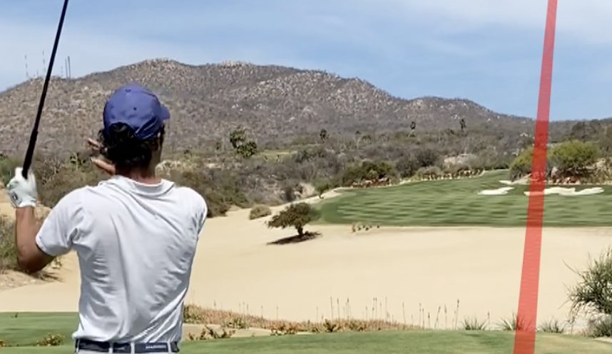 Golfer watching a curving ball flight from the tee box