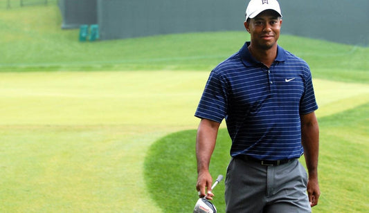Tiger Woods walking off a green with an iron - the player who made the stinger famous