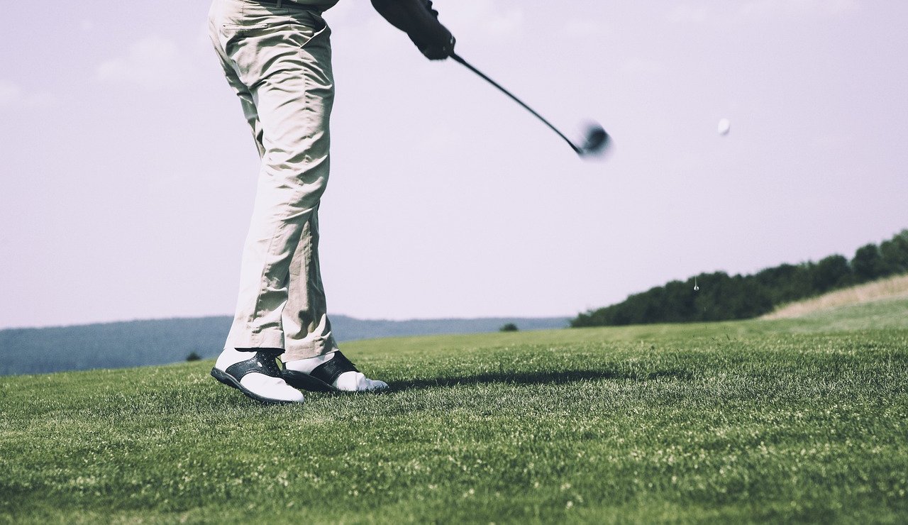 Golfer hitting a tee shot down the fairway while the group watches, the moment the Wolf decides